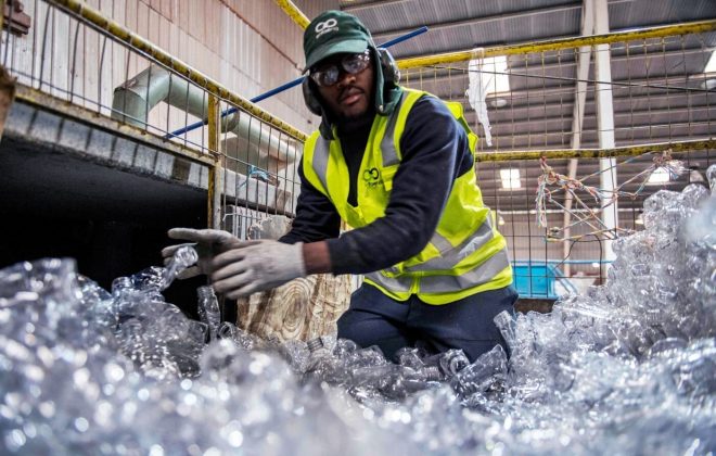 Example solutions image: An employee throws plastic bottles into a crusher to make plastic pellets at a recycling plant in Santiago, on August 21, 2019. — Countries as diverse as Chile and Panama are searching creative solutions to give the plastic a second use or prevent it to end up in the sea.